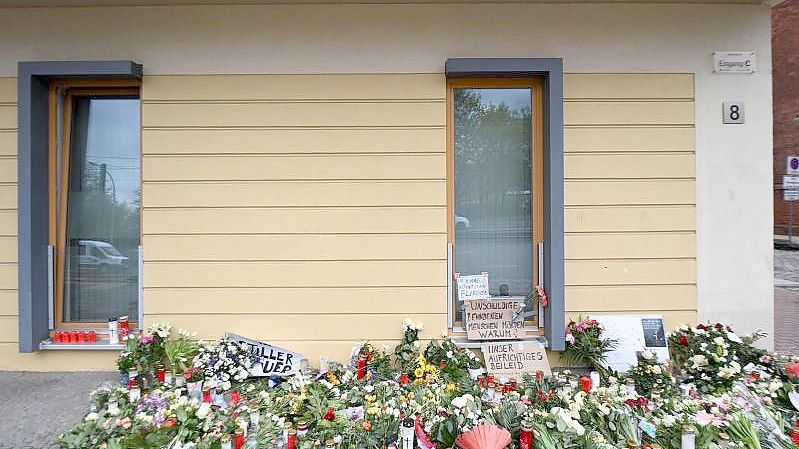 Blumen, Kerzen und Plakate erinnern vor dem Wohnheim in Potsdam an die getöteten Bewohner. Foto: Soeren Stache/dpa-Zentralbild/dpa/Archiv