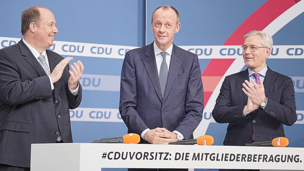 Friedrich Merz (Mitte) steht zwischen den Mitkandidaten für den CDU-Parteivorsitz Helge Braun (links) und Norbert Röttgen nach der Bekanntgabe der Ergebnisse der CDU Mitgliederbefragung. Foto: Michael Kappeler/dpa