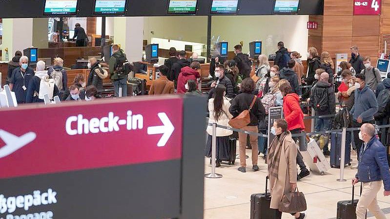 Eine Warteschlange an einem Check-in-Schalter am Flughafen BER. Foto: Joerg Carstensen/dpa