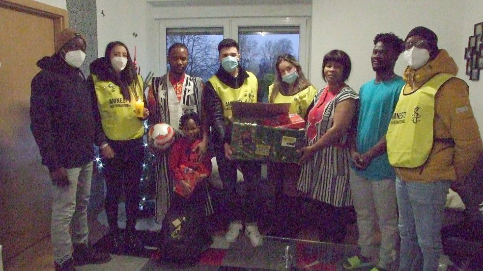 Über den Fußball freut sich Miracle (vorne). Das Foto zeigt die Beschenkten und die Schenker Ali Kone (von links), Marieke Polzin, Gbeyo, Josef Hamoud, Patricia Borges, Moin Beatrice, Serge und Mohau Brinkmann. Foto: Scherzer