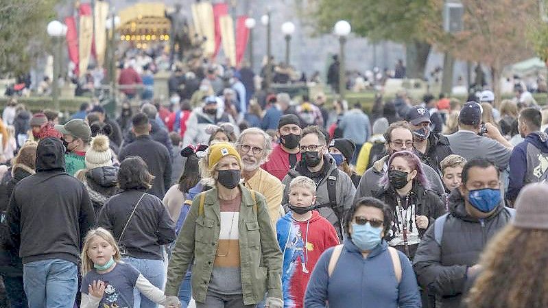 Menschen laufen durch die US-amerikanische Stadt Anaheim. In den USA ist die Omikron-Variante inzwischen die dominierende Mutante. Foto: Ringo H.W. Chiu/AP/dpa