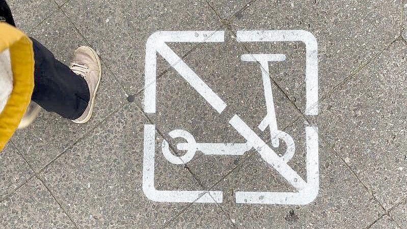 Ein Piktogramm auf einem Gehweg zeigt, dass E-Scooter-Fahrer hier nicht fahren und wild parken dürfen. Foto: Paul Zinken/dpa
