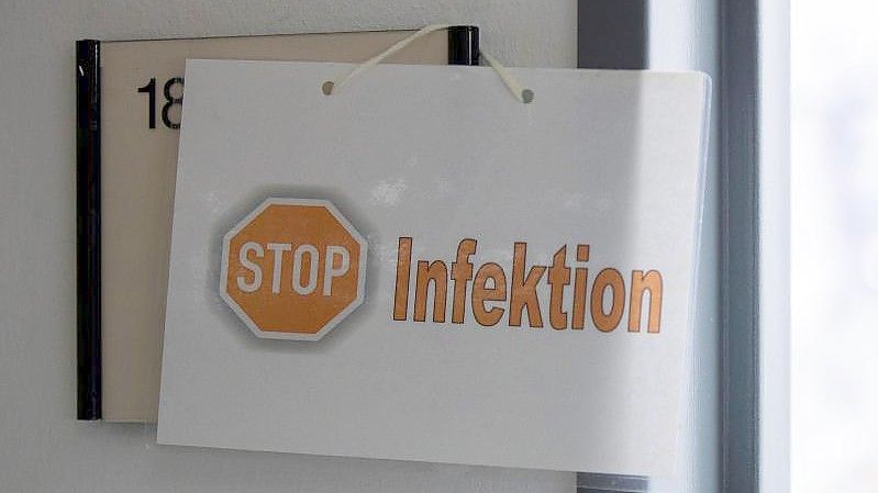 Ein Schild weist auf einer Intesivstation in Düren auf eine Corona-Infektion hin. Foto: Thomas Banneyer/dpa