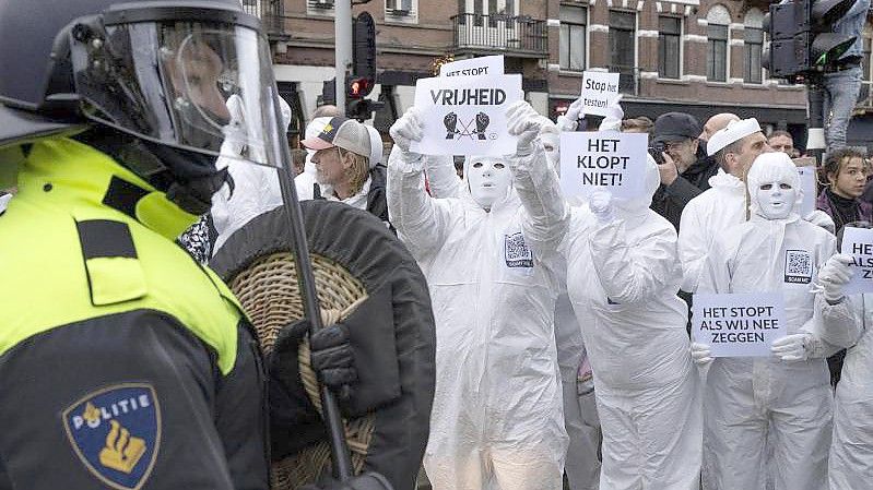 Menschen protestieren in Amsterdam bei einer verbotenen Demonstration gegen die Corona-Politik. Die Niederlande befinden sich derzeit in einem harten Lockdown, der noch bis mindestens Mitte Januar dauern soll. Foto: Peter Dejong/AP/dpa