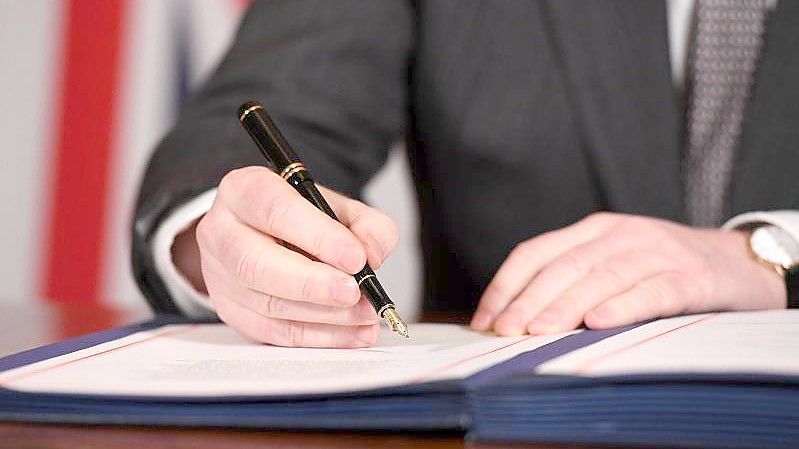 Boris Johnson unterzeichnet im Dezember 2020 den Brexit-Handelspakt mit der Europäischen Union. Foto: Leon Neal/PA Wire/dpa