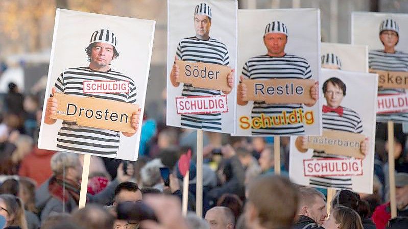 Auf einer Demonstration im November 2020 in Leipzig werden Wissenschaftler und Politiker als Sträflinge gezeigt. Foto: Sebastian Kahnert/dpa-Zentralbild/dpa