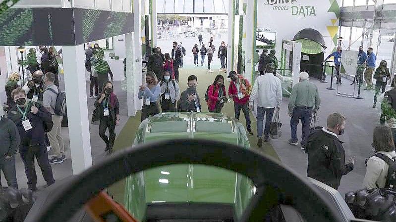 Besucher sehen sich den automatisierten Traktor von John Deere während der CES an. Foto: Joe Buglewicz/AP/dpa