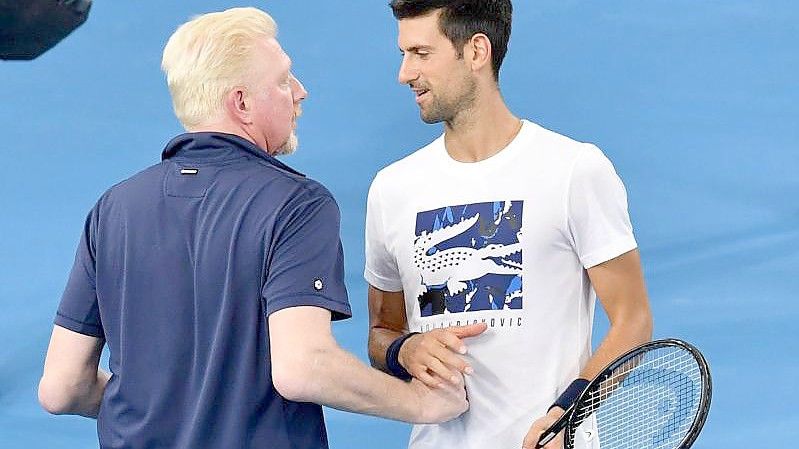 Boris Becker (l) spricht beim ATP Cup im Februar 2020 mit Novak Djokovic. Foto: Darren England/AAP/dpa