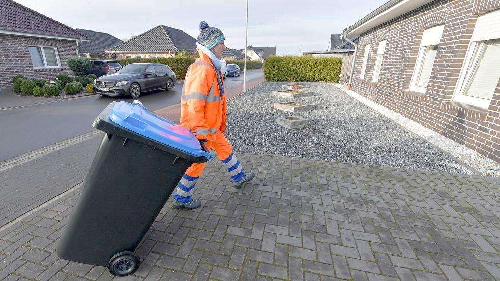 Marinella Moldovan von der Bielefelder Firma C-Trace schob die erste Blaue Tonne auf die Auffahrt eines Hauses in der Fritz-Reuter-Straße in Steenfelderfehn. Foto: Ortgies