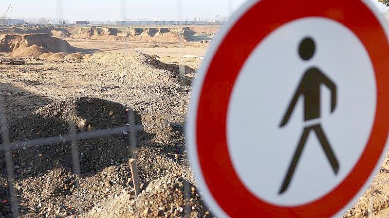 Das Verkehrsschild „Verbot für Fußgänger“ am Zaun der Kiesgrube im Stadtteil Blessem in Erftstadt. Foto: Oliver Berg/dpa