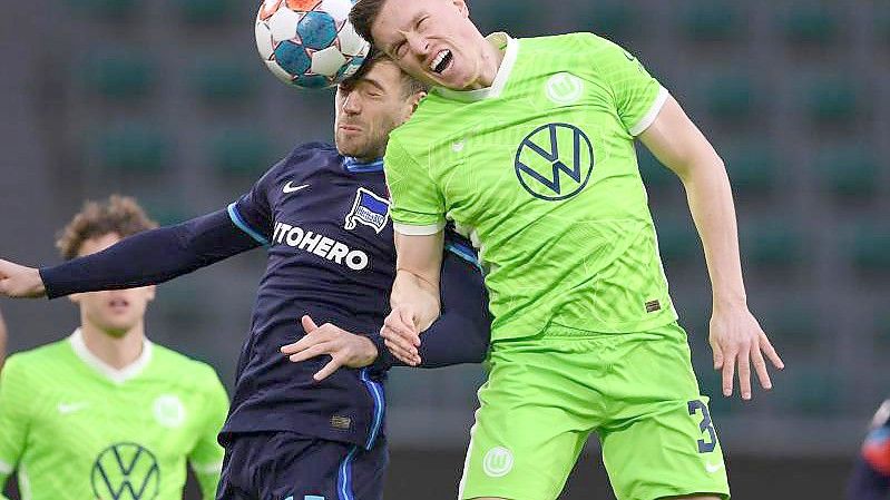 Wolfsburgs Yannick Gerhardt (r) geht ins Kopfballduell mit Berlins Lukas Klünter (M). Foto: Swen Pförtner/dpa