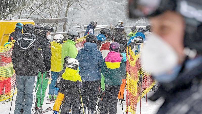 Schnee in Bayern: Skifahrer warten vor einem Schlepplift. Foto: Armin Weigel/dpa