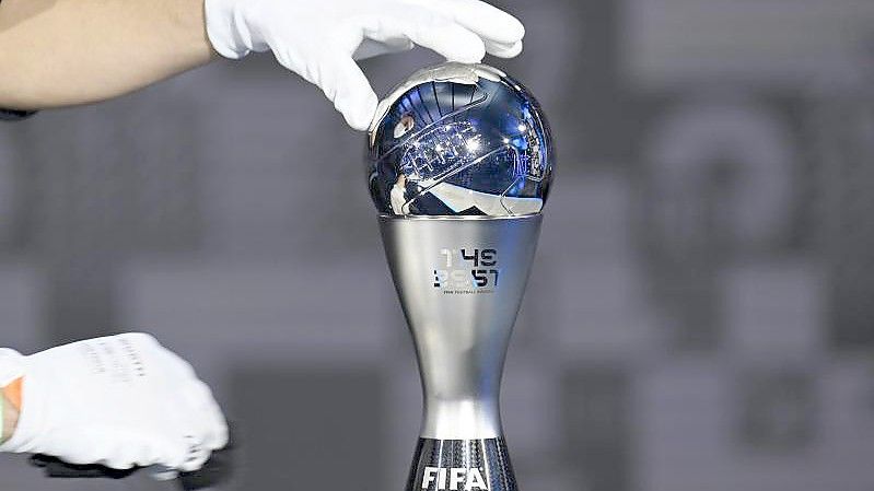 Eine der Trophäen wird vor der Preisverleihung der FIFA für die Weltfußballerin und den Weltfußballer auf einem Sockel platziert. Foto: Valeriano Di Domenico/POOL FIFA/Getty/AP/dpa