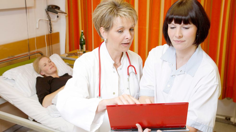 Das Symbolbild zeigt, wie eine Ärztin und eine Krankenschwester über die weitere Behandlung einer Patientin entscheiden. Archivfoto: AOK