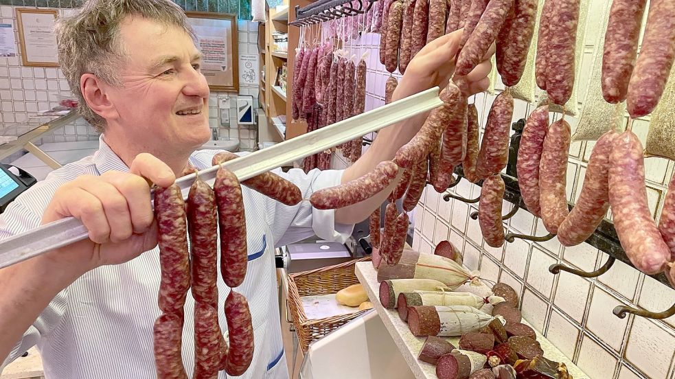 Heiner Groeneveld hängt im Laden Mettwürste auf. Sie gehören zu den letzten: Ende Januar schließt die Fleischerei. Foto: Janßen