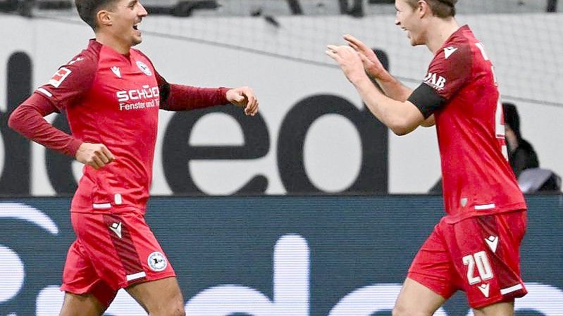 Die Bielefelder Alessandro Schöpf (l) und Patrick Wimmer jubeln nach dem Tor zum 2:0 bei Eintracht Frankfurt. Foto: Arne Dedert/dpa