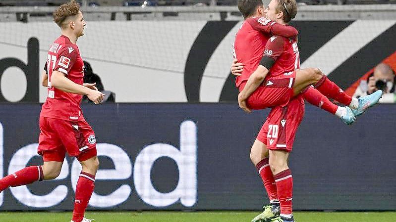 Bielefelds Torschütze Alessandro Schöpf (M) springt Vorlagengeber Patrick Wimmer in die Arme. Foto: Arne Dedert/dpa