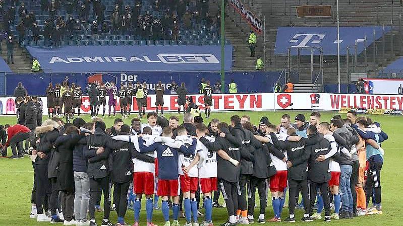 Die Spieler des HSV feiern nach dem Schlusspfiff den Sieg gegen den FC St. Pauli. Foto: Christian Charisius/dpa