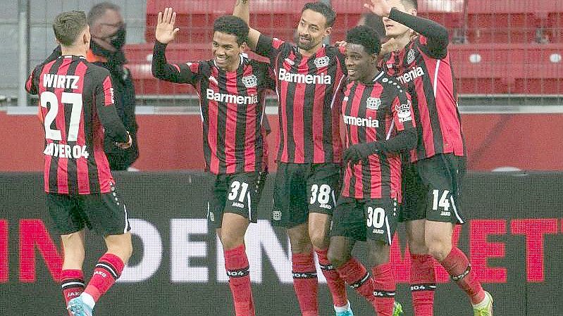 Die Spieler von Bayer Leverkusen feiern den frühen Führungstreffer gegen die Gäste aus Augsburg. Foto: Marius Becker/dpa