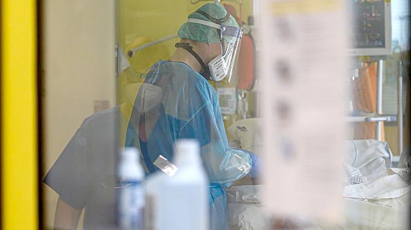 Ein Intensivpfleger ist auf einer Covid-19 Intensivstation. Foto: Robert Michael/dpa-Zentralbild/dpa