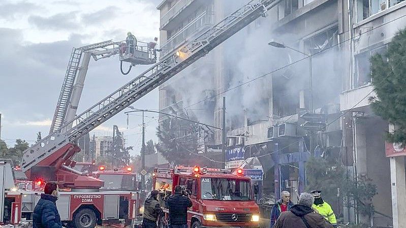 Feuerwehrleute suchen mit Hilfe von Drehleitern nach Personen, die nach einer Explosion in den beschädigten Gebäuden eingeschlossen sind. Foto: Derek Gatopoulos/AP/dpa