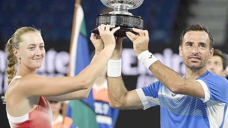 Kristina Mladenovic und Ivan Dodig halten ihre Trophäe nach ihrem Sieg in die Höhe. Foto: Andy Brownbill/AP/dpa