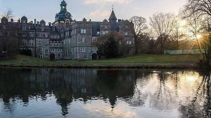 Die Sonne geht hinter dem Schloss Bückeburg in Niedersachsen auf. Foto: Lino Mirgeler/dpa