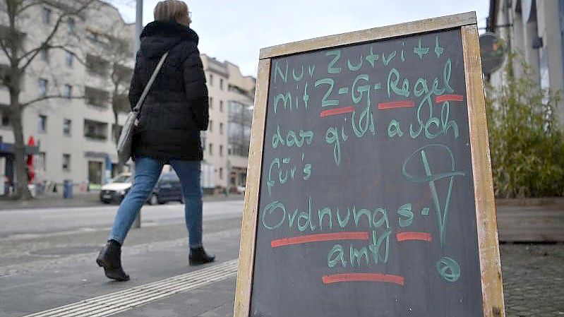 Vor einem Geschäft im Potsdamer Stadtteil Babelsberg steht ein Hinweisschild mit der Aufschrift „Nur Zutritt mit 2G-Regel das gilt auch fürs Ordnungsamt“. Foto: Britta Pedersen/dpa-Zentralbild/dpa