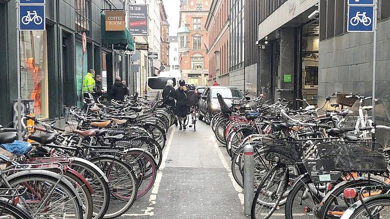 Auch in Kopenhagen gibt es noch ganz klassische Parkhäuser für Autos - direkt daneben ein Fahrradparkplatz. Foto: Steffen Trumpf/dpa