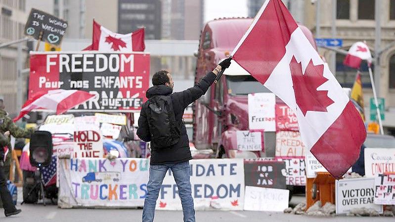 Ein Demonstrant schwenkt bei einem Protest gegen die Corona-Maßnahmen in Ottawa eine kanadische Flagge. Foto: Justin Tang/The Canadian Press/dpa