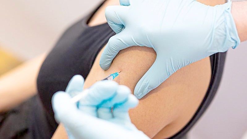 Eine Frau wird von einem Arzt gegen das Coronavirus geimpft. Foto: Moritz Frankenberg/dpa