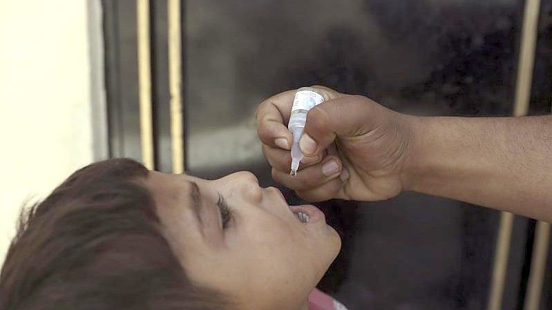 Ein Mann verabreicht einem Kind eine Impfung während einer Polio-Kampagne in Afghanistan. Die UN meldet nun, dass acht Impfhelfer getötet wurden. Foto: Rahmat Gul/AP/dpa