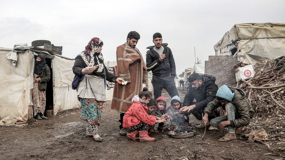 Migranten aus Syrien versammeln sich im Libanon um ein kleines Feuer, um sich zu wärmen. Viele Syrer stellen Asylanträge in Deutschland. Das Land Niedersachsen hat deshalb im August 2021 eine neue Verteilquote erlassen. Das macht sich auch im Kreis Cloppenburg bemerkbar. Foto: Naamani/DPA
