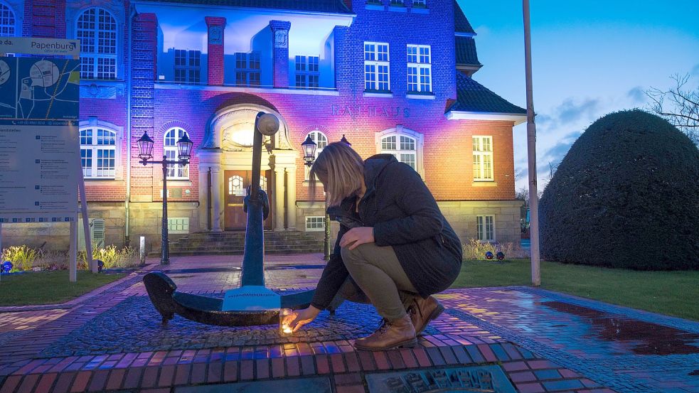 Das Papenburger Rathaus wird in den Farben der Ukraine angestrahlt. Bürgermeisterin Vanessa Gattung hat eine Kerze niedergelegt. Foto: Lohmann