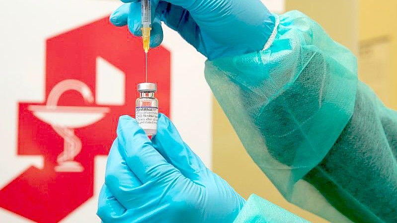 Eine Apothekerin zieht den Impfstoff Comirnaty vom Hersteller Biontech / Pfizer mit einer Spritze auf. Foto: Friso Gentsch/dpa