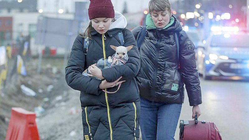 Zwei geflüchtete Frauen kommen mit einem Hund am Grenzübergang Medyka in Polen an. Foto: Visar Kryeziu/AP/dpa