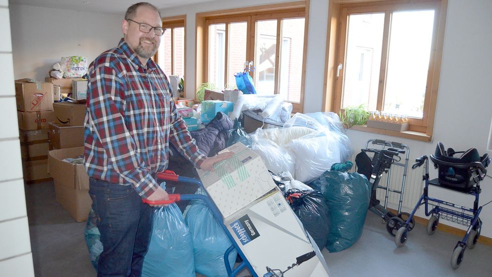 Mit einer Sackkarre transportiert Saterlands Bürgermeister Thomas Otto die Hilfsgüter, die die Saterländer für Kriegsflüchtlinge aus der Ukraine spenden, ins Obergeschoss des Rathauses. Die ehemalige Teeküche hat sich rasch gefüllt, alleine mit den Gütern, die an diesem Freitag zur Verfügung gestellt wurden. Foto: Fertig