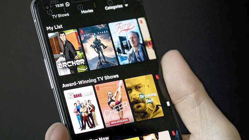 Auf dem Bildschirm eines Smartphones sieht man in der App von Netflix das Filmangebot des Streaminganbieters. Foto: Fabian Sommer/dpa