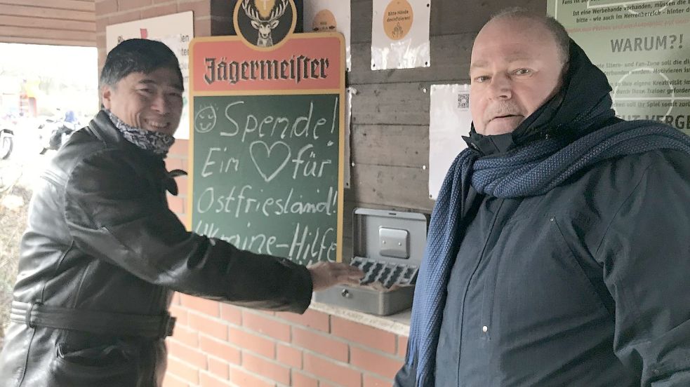 Uwe Freesemann (rechts), der bei den Spielen in Völlen das Eintrittsgeld kassiert, hat am Sonntag die Fußballfans um eine Spende für das Hilfswerk „Ein Herz für Ostfriesland“ gebeten. VfR-Mitglied Peter Duong spendetet gerne für die Flüchtlingshilfe. Foto: Privat