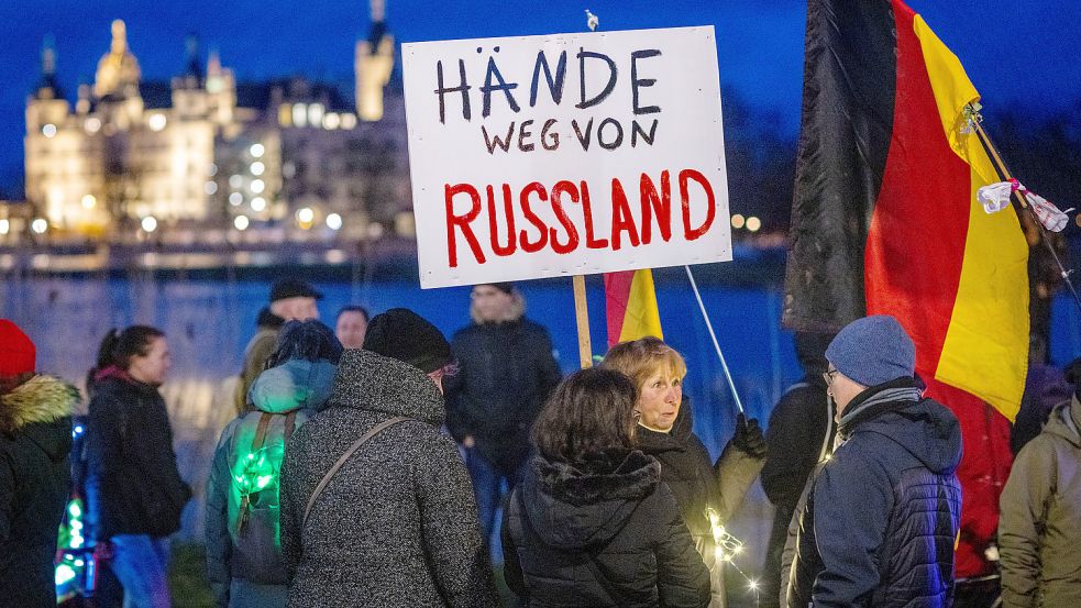 Teilnehmer der Protestaktion gegen die Corona-Schutzmaßnahmen halten ein Schild mit der Aufschrift „Hände weg von Russland“. Die Corona-Proteste boten Rechtsextremen zuletzt eine gute Grundlage, um viele Menschen zu mobilisieren. Mit dem Ukraine-Krieg hat die Rechte ein neues Thema gefunden – jedoch noch keine einheitliche Linie. Einige wenige Akteure haben aber offenbar ein klares Ziel. Foto: Jens Büttner/dpa-Zentralbild/dpa