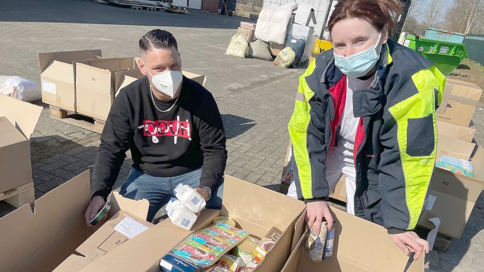 Antonella Lucchetta und Pascal Rülander sortieren Kisten nach Inhalt: Hygieneartikel, Nahrung, Malbücher. Foto: Janßen