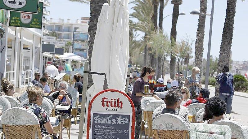 Kunden sitzen im Außenbereich einer Gaststätte in Palma. Foto: Clara Margais/dpa