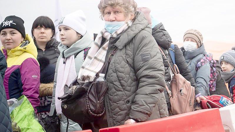 Geflüchtete aus der Ukraine stehen kurz hinter dem Grenzübergang Medyka für einen Bus an. Foto: Sebastian Gollnow/dpa