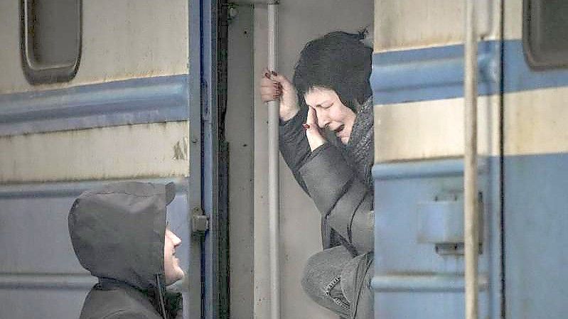 Eine Frau verabschiedet sich am Bahnhof in Kiew. Foto: Vadim Ghirda/AP/dpa