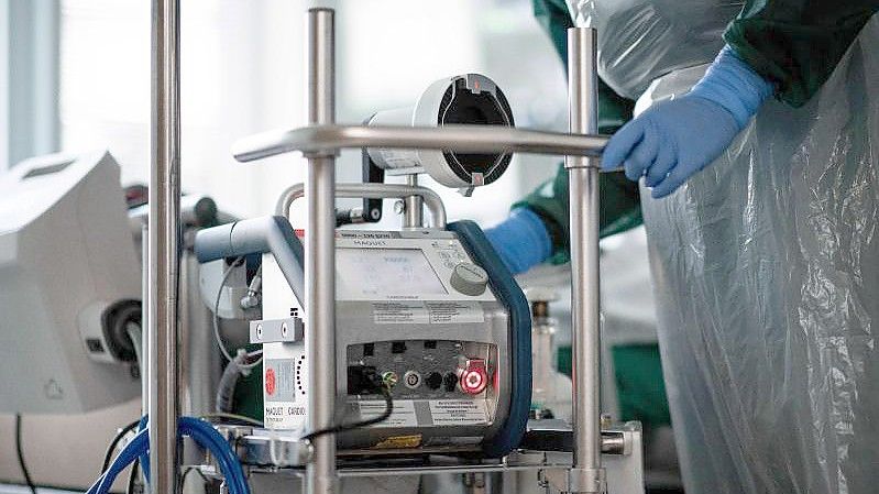 Mitarbeiterin einer Corona-Intensivstation mit einem Ecmo-Gerät. Foto: Fabian Strauch/dpa