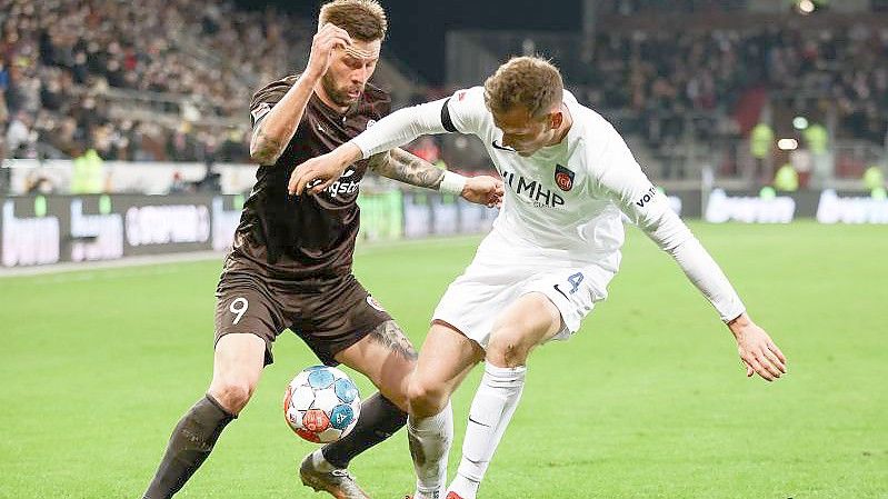 Guido Burgstaller (l) konnte mit St. Pauli wieder die Tabellenführung übernehmen. Foto: Christian Charisius/dpa