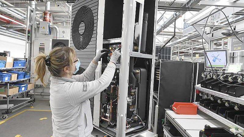 Eine Mitarbeiterin der Firma Vaillant montiert eine Wärmepumpe im Stammwerk des Unternehmens in Remscheid. Foto: Roberto Pfeil/dpa