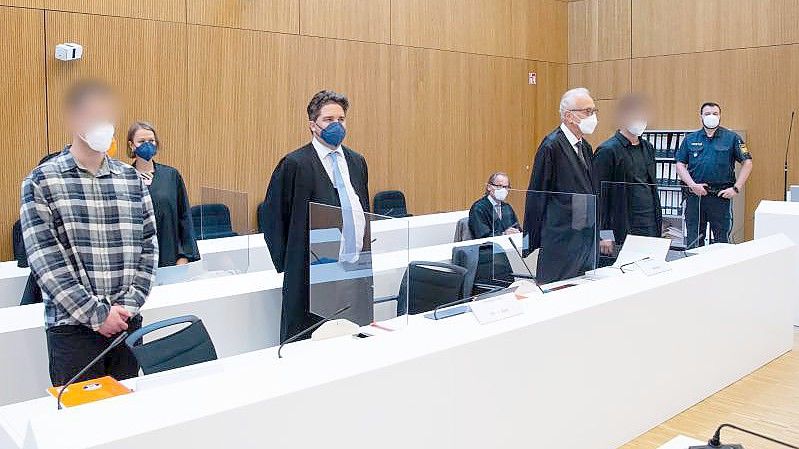 Die zwei wegen Mordes angeklagten Männer (l und 2.v.r.) mit ihren Anwälten vor Beginn der Verhandlung im Sitzungssaal. Foto: Sven Hoppe/dpa