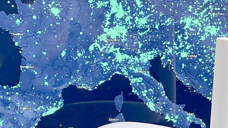 Ein Funk-Hotspot des Helium-Netzwerks vor einer Karte der Netzabdeckung in Europa. Foto: Christoph Dernbach/dpa
