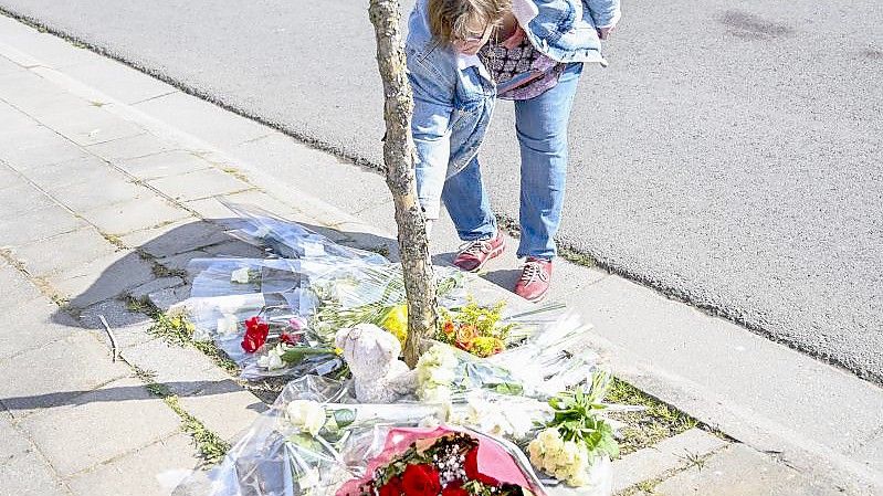 Eine Frau legt Blumen an der Unfallstelle nieder. Foto: Laurie Dieffembacq/BELGA/dpa